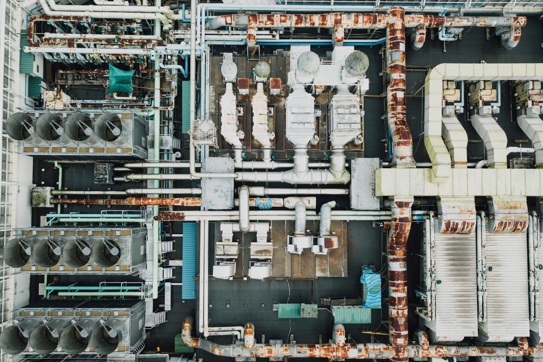 Industrial plant rooftop pipes and manufacturing equipment from aerial view